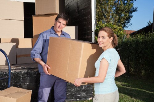 Movers carrying boxes and furniture from a Fulham property